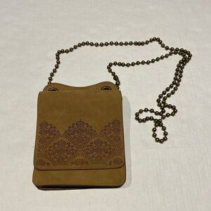 Adjustable strap crossbody bag featuring laser cutout’s on front flap